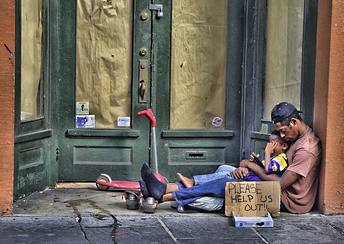 apparently homeless person in doorway with child